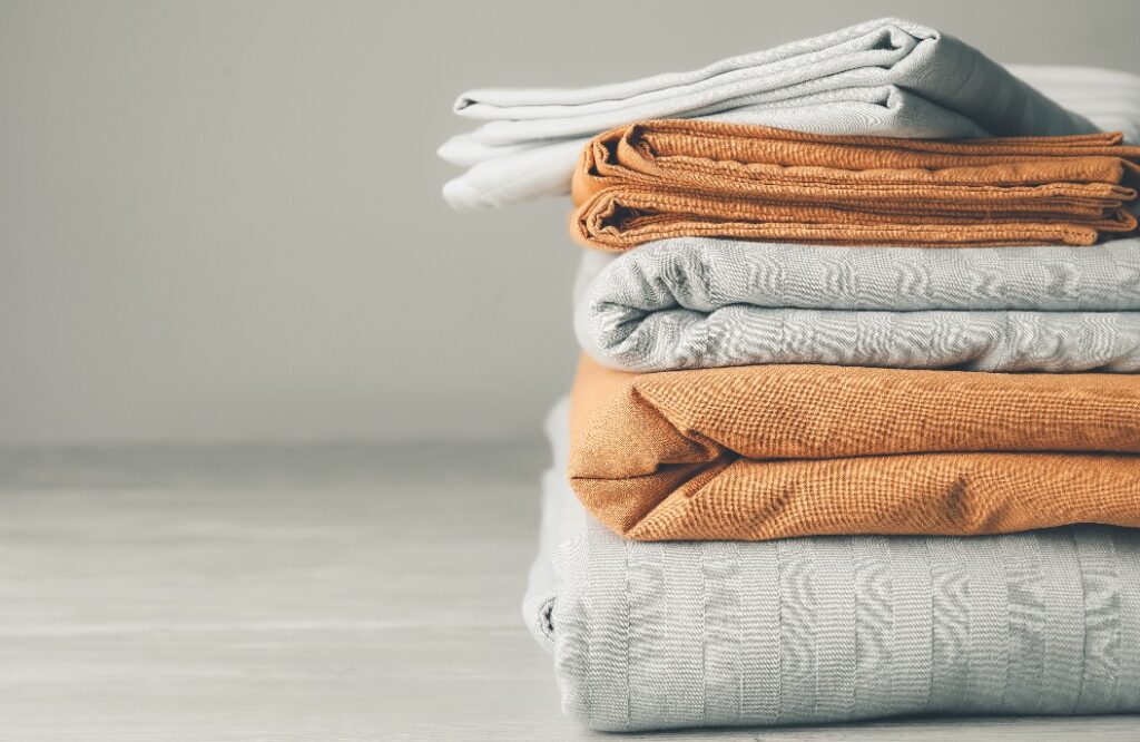 Stack of clean bed sheets on table